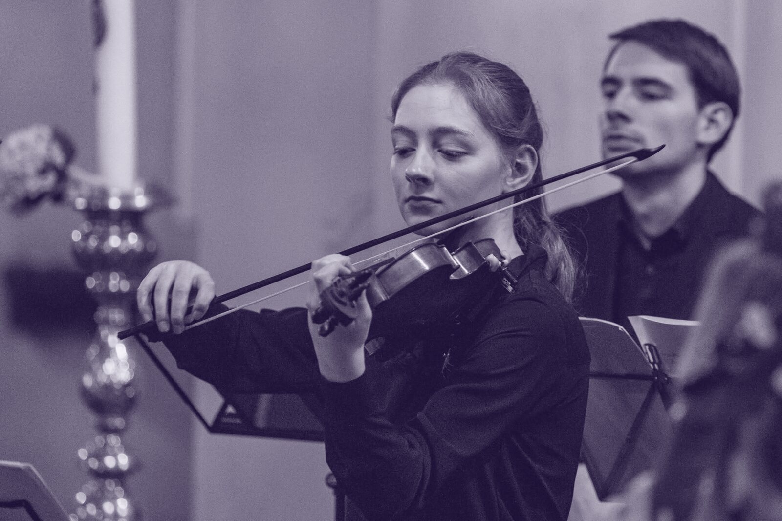 Een musicus van de Cantatekaravaan speelt bij kaarslicht